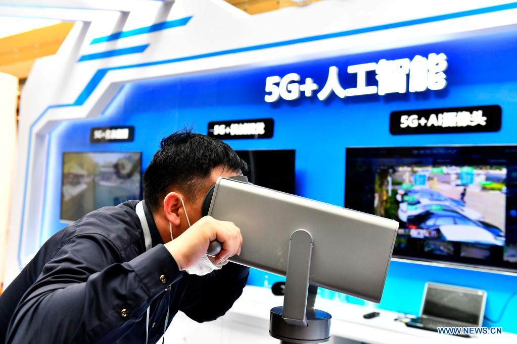 An attendee tries a smart device during the 1st Summit of Jinan National Artificial Intelligence Innovation and Application (JNAIIA) Pilot Zone & the Exposition of Artificial Intelligence Innovation and Application on Yellow River Basin in Jinan, east China