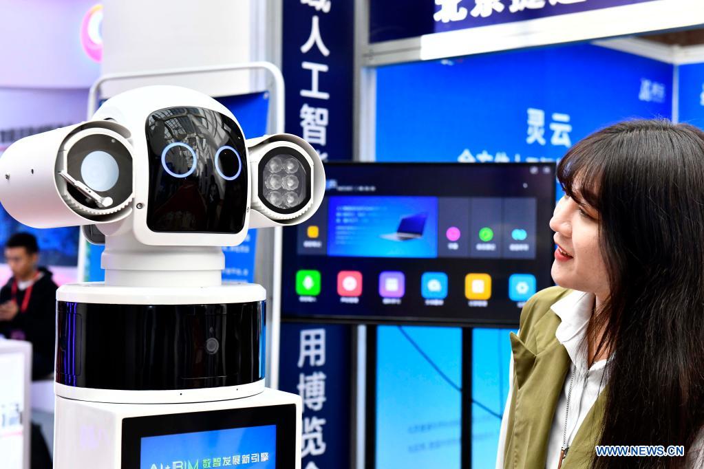 An attendee interacts with a robot during the 1st Summit of Jinan National Artificial Intelligence Innovation and Application (JNAIIA) Pilot Zone & the Exposition of Artificial Intelligence Innovation and Application on Yellow River Basin in Jinan, east China