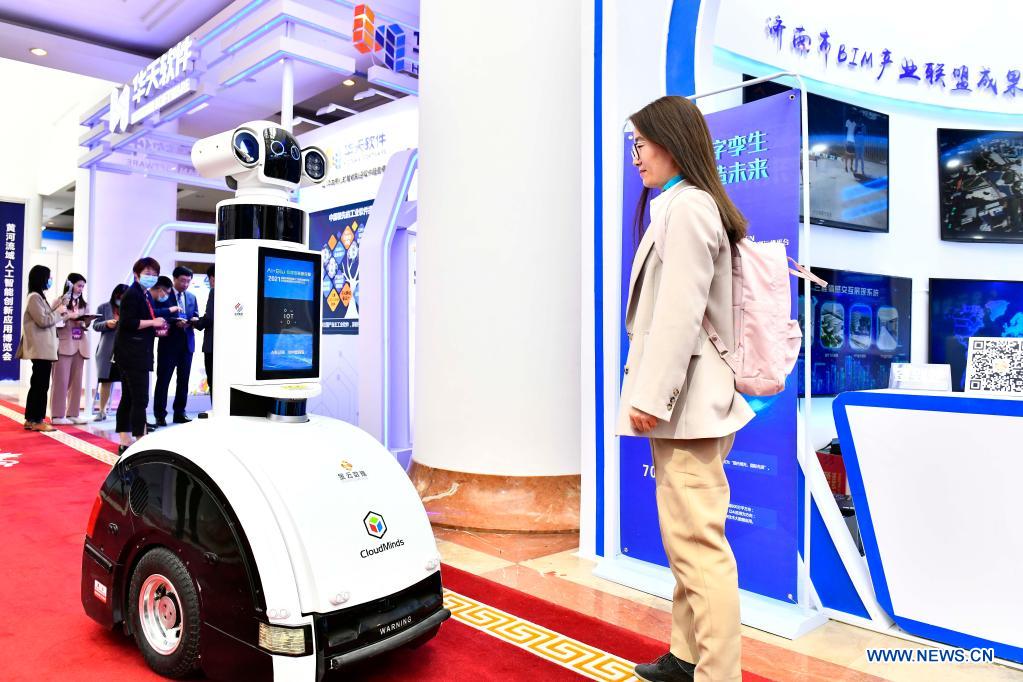 An attendee views a smart device during the 1st Summit of Jinan National Artificial Intelligence Innovation and Application (JNAIIA) Pilot Zone & the Exposition of Artificial Intelligence Innovation and Application on Yellow River Basin in Jinan, east China