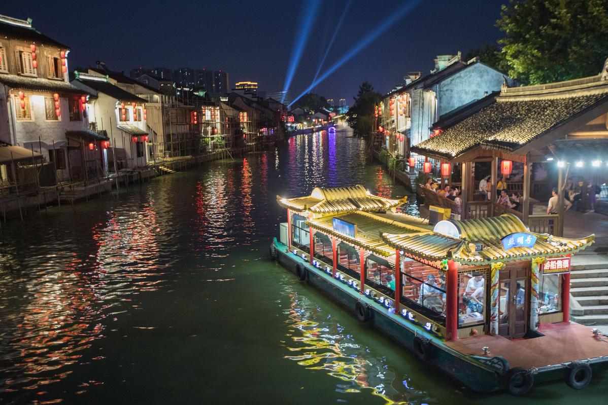 The quaint buildings along the waterway and charming bridges over the ancient canal in Wuxi feature beautiful illuminations in the evening. [Photo/VCG]
