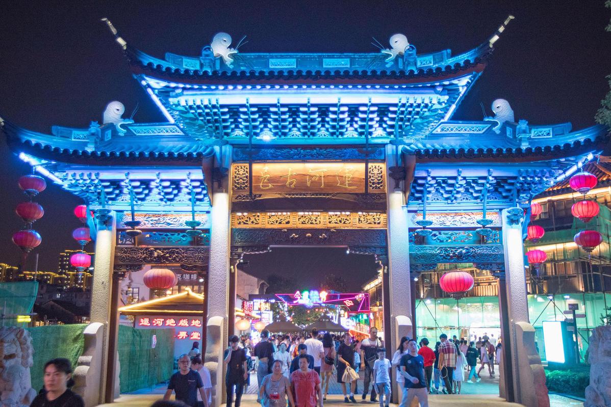 The quaint buildings along the waterway and charming bridges over the ancient canal in Wuxi feature beautiful illuminations in the evening. [Photo/VCG]