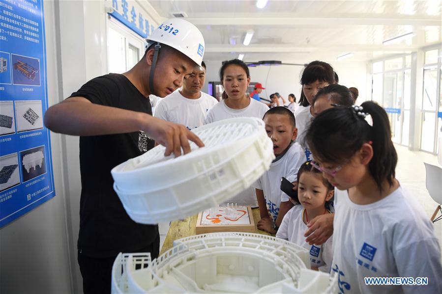 A staff member of the China Construction Third Engineering Bureau Co., Ltd. displays 3D printing model during a caring activity in Anning District of Lanzhou, northwest China