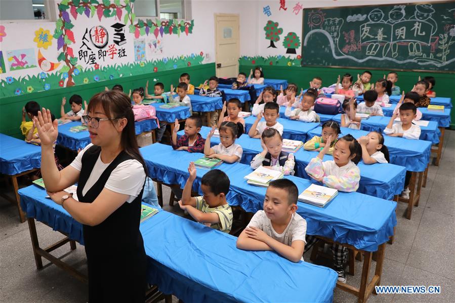 A teacher demonstrates class rules at a primary school in Longnan City, northwest China