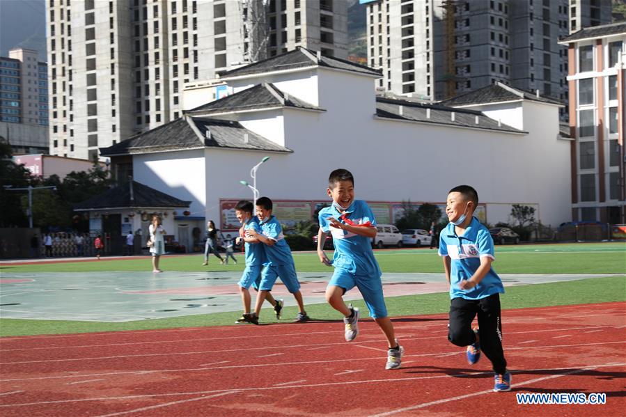 Pupils run on the playground at a primary school in Longnan City, northwest China