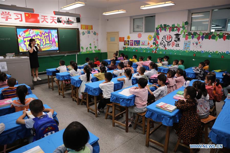 Pupils have the first class at a primary school in Longnan City, northwest China