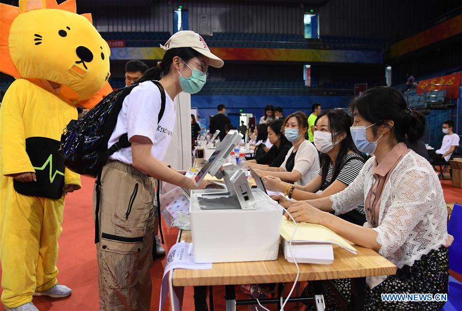 A freshman (2nd L) registers at the Khoo Teck Puat Gymnasium of the Peking University in Beijing, capital of China on Sept. 1, 2020. As the new school year starts, college students are returning to campus in Beijing under tight epidemic prevention and control measures. (Xinhua/Ren Chao)