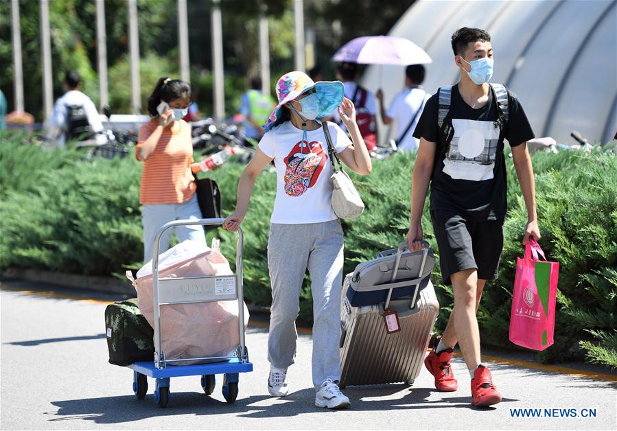 A freshman (1st R) walks with a family member (2nd R) in the campus of the Peking University in Beijing, capital of China on Sept. 1, 2020. As the new school year starts, college students are returning to campus in Beijing under tight epidemic prevention and control measures. (Xinhua/Ren Chao)