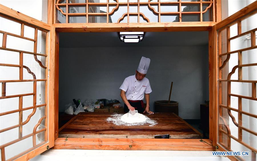 Zhang Xu makes mooncake crust with malt sugar syrup and flour at the mooncake bakery Jingshengchang in Xiayi County, Shangqiu, central China