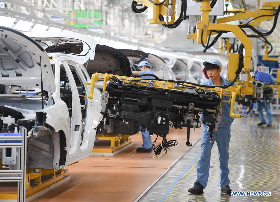 A worker installs a console into a car at a passenger car workshop of Ningde base of SAIC Motor Corporation Ltd. in Ningde, southeast China