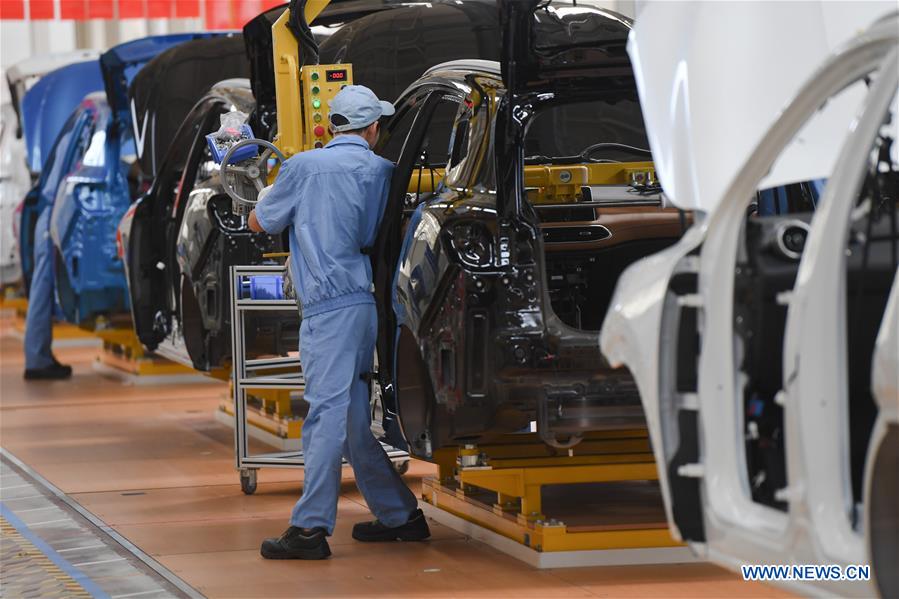 People work on the assembly line at a passenger car workshop of Ningde base of SAIC Motor Corporation Ltd. in Ningde, southeast China