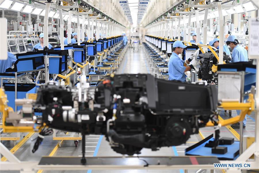 Workers assemble control system of instrument panel at a passenger car workshop of Ningde base of SAIC Motor Corporation Ltd. in Ningde, southeast China