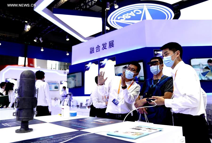 Exhibitors introduce exhibits to a visitor at the 22nd China International Industry Fair (CIIF) in east China