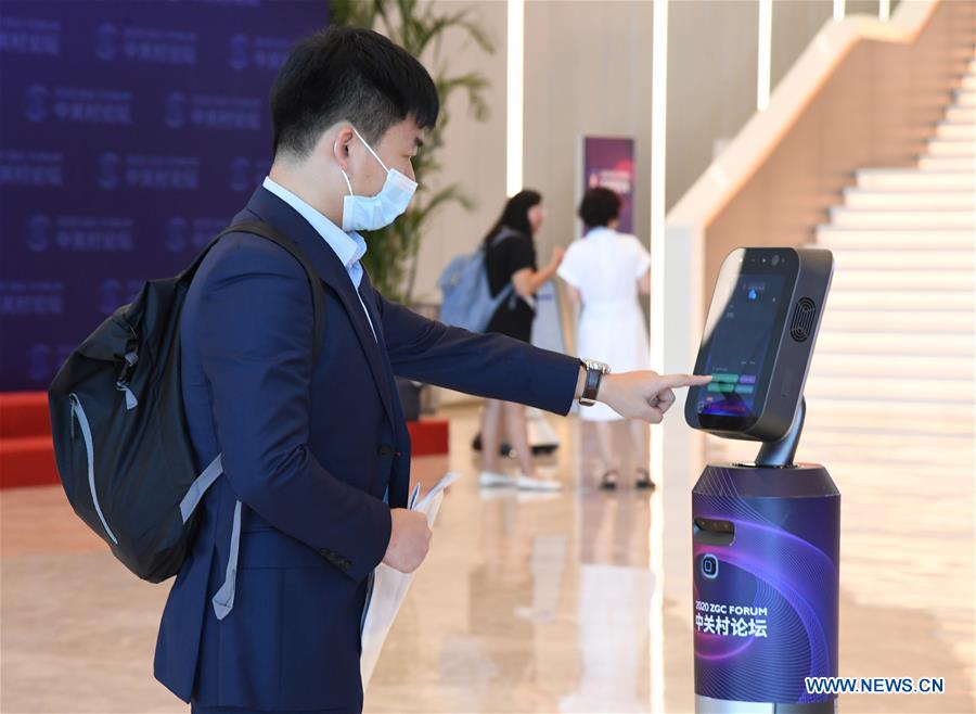 A man gets information from a service robot at the main venue of the 2020 Zhongguancun Forum (ZGC Forum) in Beijing, capital of China, Sept. 17, 2020. The forum will be held in Beijing from Sept. 17 to 20. (Xinhua/Ren Chao)