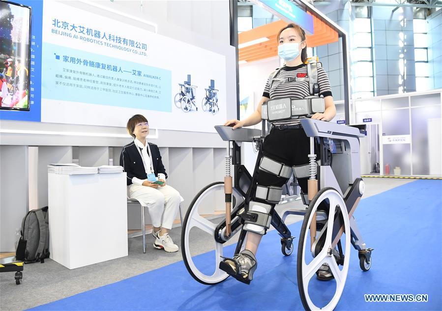 A staff member demonstrates an exoskeleton robot used in rehabilitation during the 2020 Zhongguancun Forum (ZGC Forum) in Beijing, capital of China, Sept. 17, 2020. During the forum held from Sept. 17 to 20, more than 50 activities will be organized including conferences, exhibitions, transactions, and releases, with online livestream channels available to the public. The 23rd China Beijing International High-tech Expo is held together with the ZGC Forum, showcasing the latest technological achievements to the world. (Xinhua/Ren Chao)