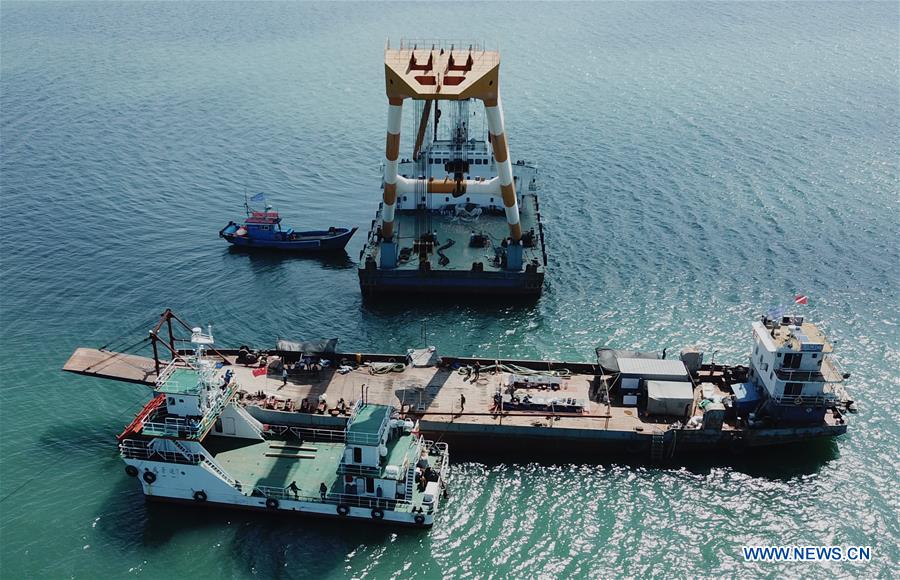 A crane works to lift the wreckage of the Dingyuan Battleship out of seawater near Liugong Island in the city of Weihai, east China