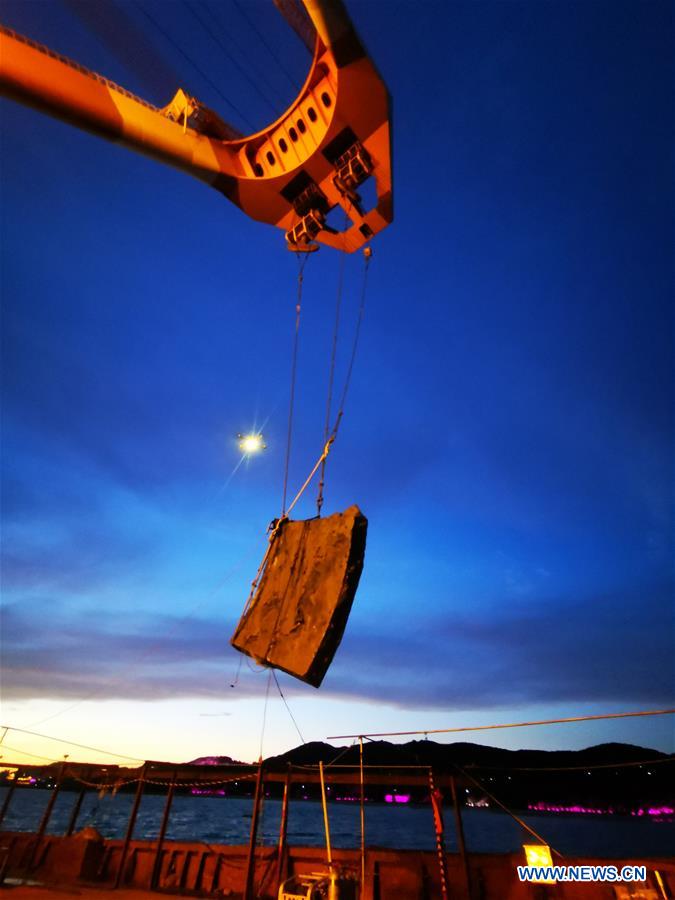 An iron plate of the Dingyuan Battleship is lifted out of seawater near Liugong Island in the city of Weihai, east China