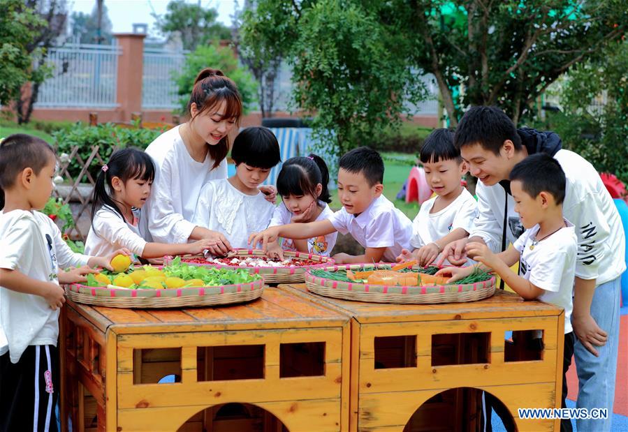 Children make pictures with crops during an event held ahead of farmers