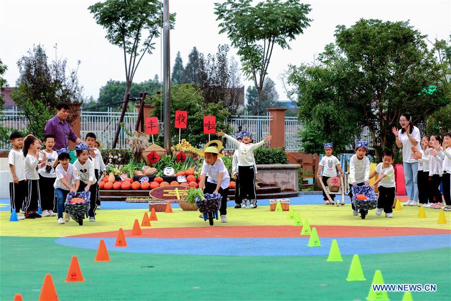 Children take part in a crops transporting competition during an event held ahead of farmers