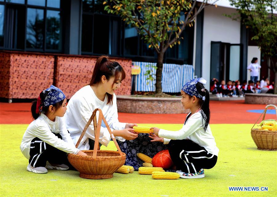 A teacher teaches children to recognise crops during an event held ahead of farmers