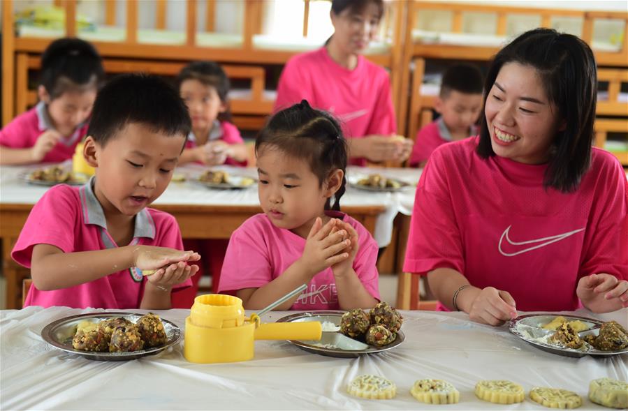 Children make mooncakes to celebrate the upcoming Mid-Autumn Festival in a kindergarten in Cangzhou City, north China