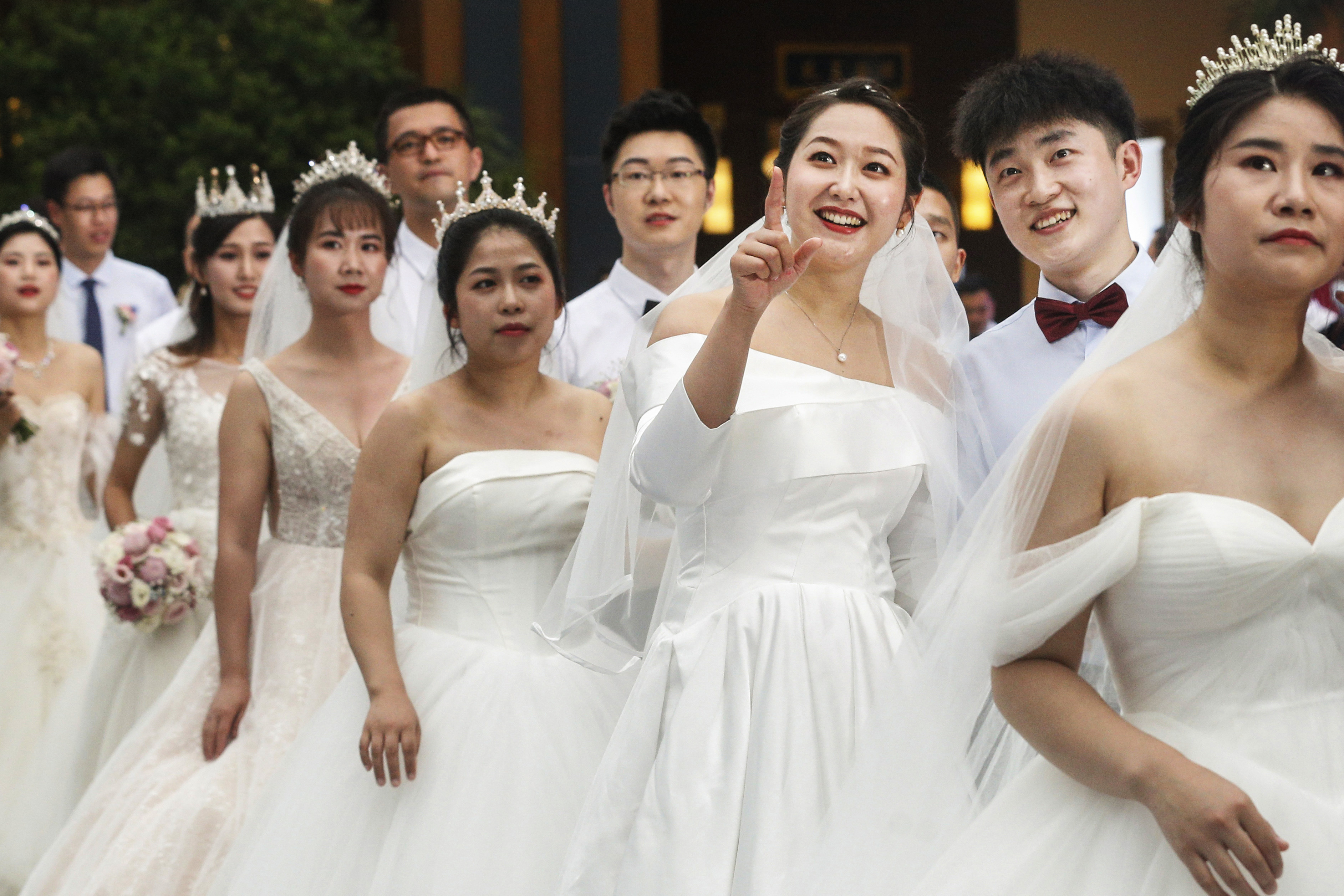 Cui (third from right) and Yao (second from right) join a group wedding held in Bo