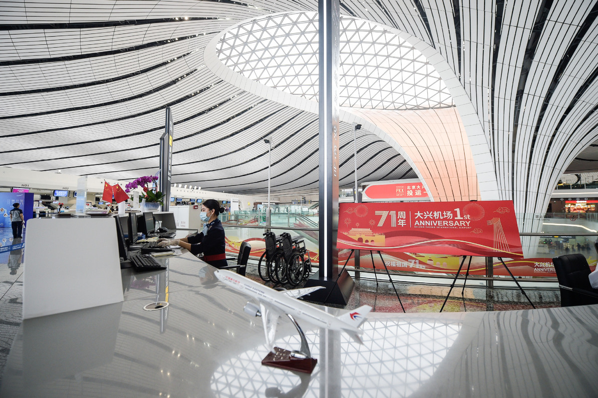 A staff worker assists a passenger to check in at Beijing Daxing International Airport in Beijing, on Sept 25, 2020. [Photo/Xinhua]In the long run, the carrier is estimated to operate more than 200 planes at the airport and handle 28.8 million passenger trips annually by 2025, he added.Feng Dehua, deputy general manager of China Eastern Airlines, noted that the carrier has also moved 87 percent of the flights to the airport and operated 280 flights per day, accounting for more than 40 percent of flights at the airport.To date, 26 domestic and overseas carriers operate from the airport, including Air China, China United Airlines and Xiamen Air, as well as British Airways and Finnair. There are 202 passenger routes connecting to 143 destinations globally operating from Daxing, as well as five cargo routes.Daxing airport is now bracing for surging passenger traffic, as some 750,000 air trips are expected to be made during the coming eight-day National Day holiday, with about 95,000 trips to be made on a daily basis, according to the airport.Located 46 kilometers south of downtown Beijing, the new aviation hub is expected to handle 45 million passenger trips a year by 2022 and 72 million by 2025, taking pressure off the Beijing Capital International Airport.