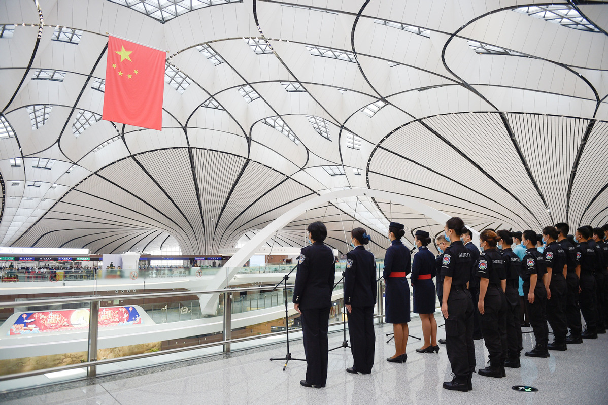 A staff member works at the information desk at Beijing Daxing International Airport in Beijing, on Sept 25, 2020. [Photo/Xinhua]