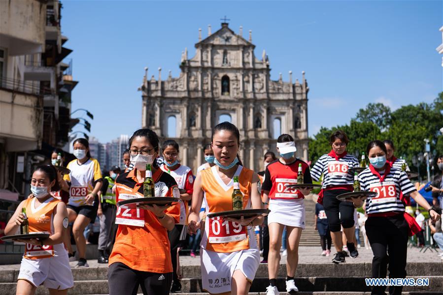 Contestants take part in the tray race in Macao, south China, Sept. 27, 2020. A tray race running from the Ruins of St. Paul