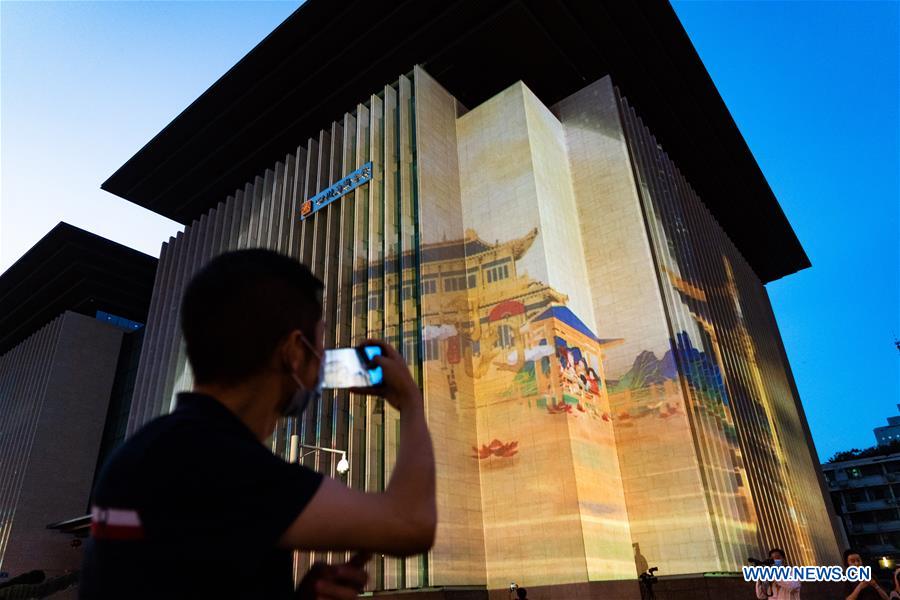 A man takes photos of a projection show staged at Sichuan Library in Chengdu, capital of southwest China