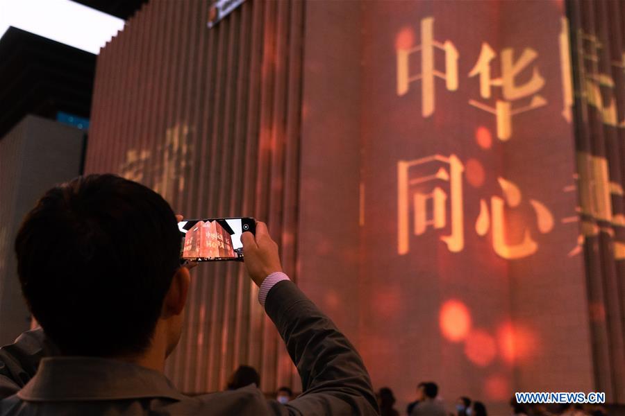 A man takes photos of a light show staged at Sichuan Library in Chengdu, capital of southwest China