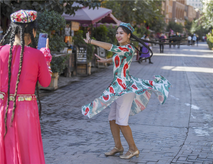 A woman dances on a street in the Old Town. ZHAO GE/XINHUAAn ancient settlement is thriving in the wake of renovation work. Cui Jia reports from Kashgar, Xinjiang Uygur autonomous region.When Mardan Ablimit opened a coffee shop in the Old Town of Kashgar, Xinjiang Uygur autonomous region, in 2018, many people warned him that his venture was unrealistic and bound to fail.Now, the 34-year-old is considering opening branches outside the region and exporting a taste of Kashgar nationwide after the coffee shop successfully integrated with the Old Town and became part of local people