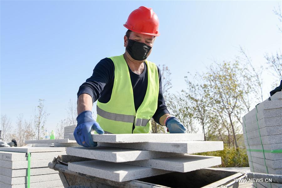 A builder works at a construction site of an ecological project in Changji City, northwest China