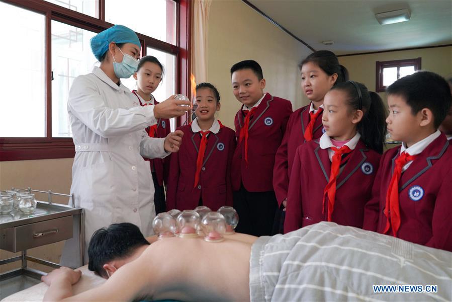Pupils watch the demonstration of cupping therapy, a traditional Chinese method of healthcare, at a hospital in Neiqiu County, north China