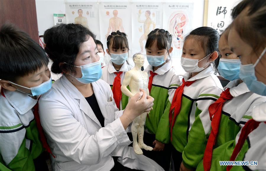 A medical worker teaches pupils knowledge of acupoint in Handan, north China