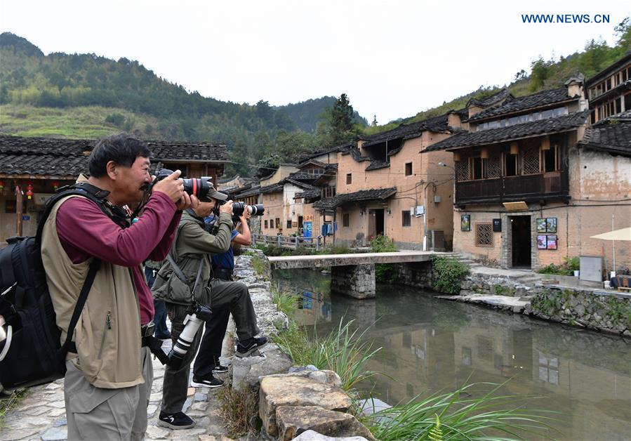 People take photos in Longtan Village of Pingnan County in Ningde City, southeast China