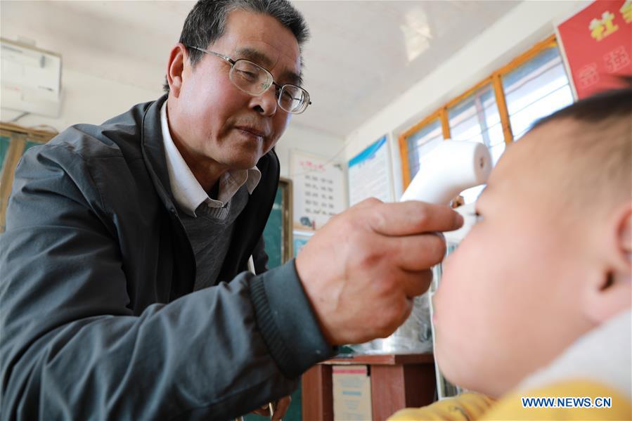 Wang Jianlin checks temperature of students in Changshan School, Huining County, northwest China