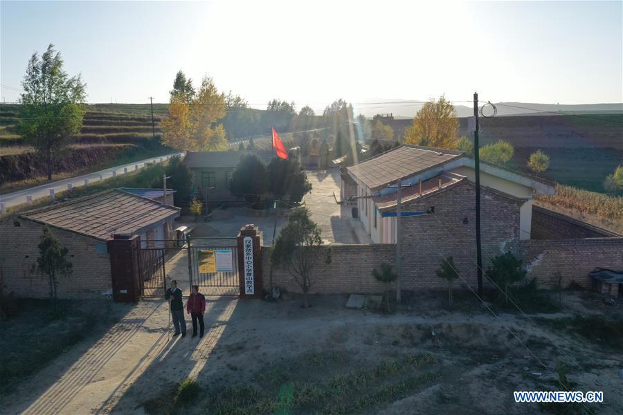 Aerial photo shows Wang Jianlin and his wife seeing students off after school in Changshan School, Huining County, northwest China