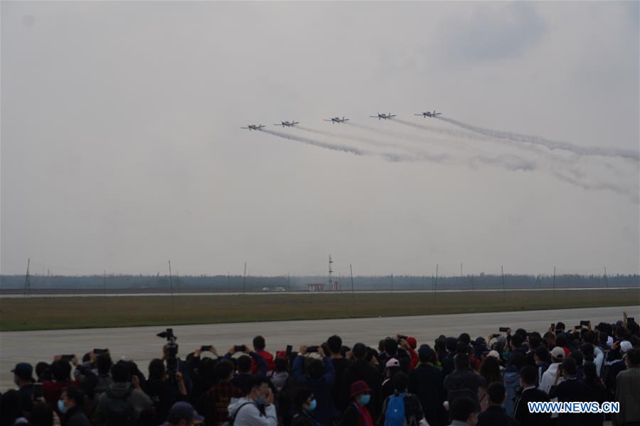 People watch the performance of an aerobatic team from China