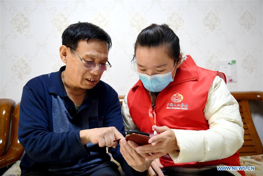 Census taker (R) helps to register residents