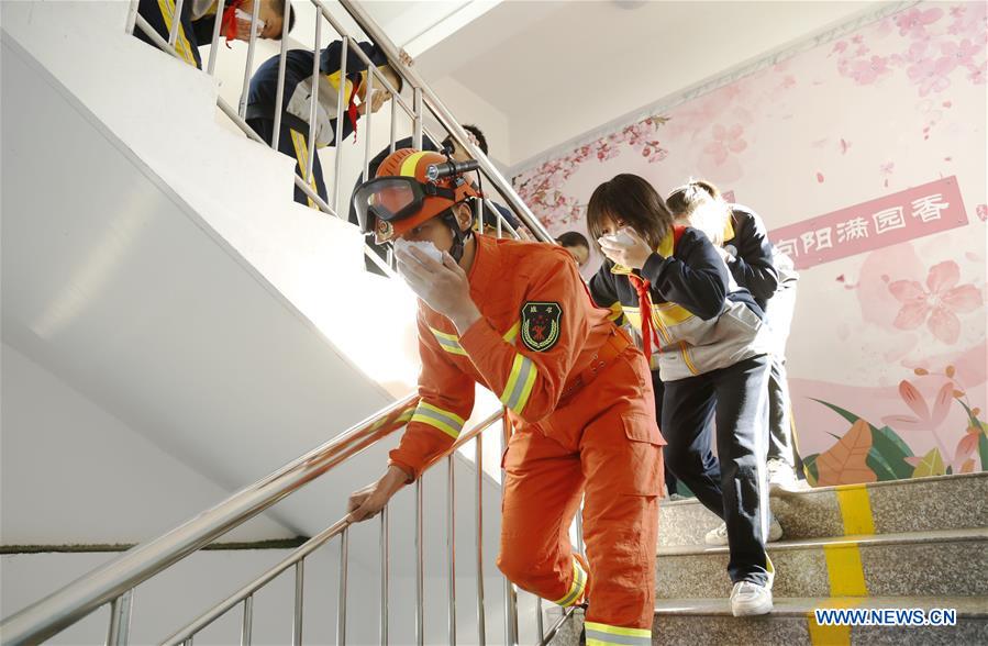 Students partake a fire drill following the instruction of a firefighter at a school in Xingtai City, north China