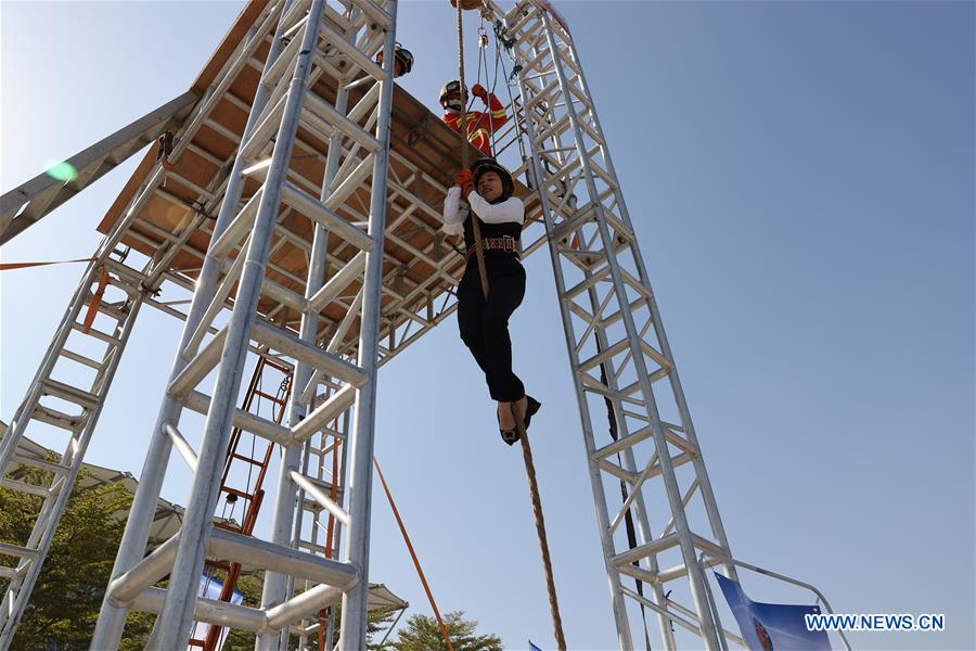 A resident practises cable descent under the instruction of firefighters in Xiamen, southeast China