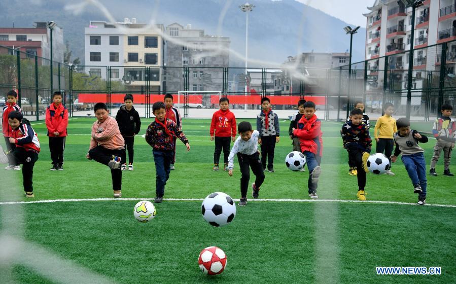 Kids play football during a football class at a resettlement site in Gaoluo Town of Xuan