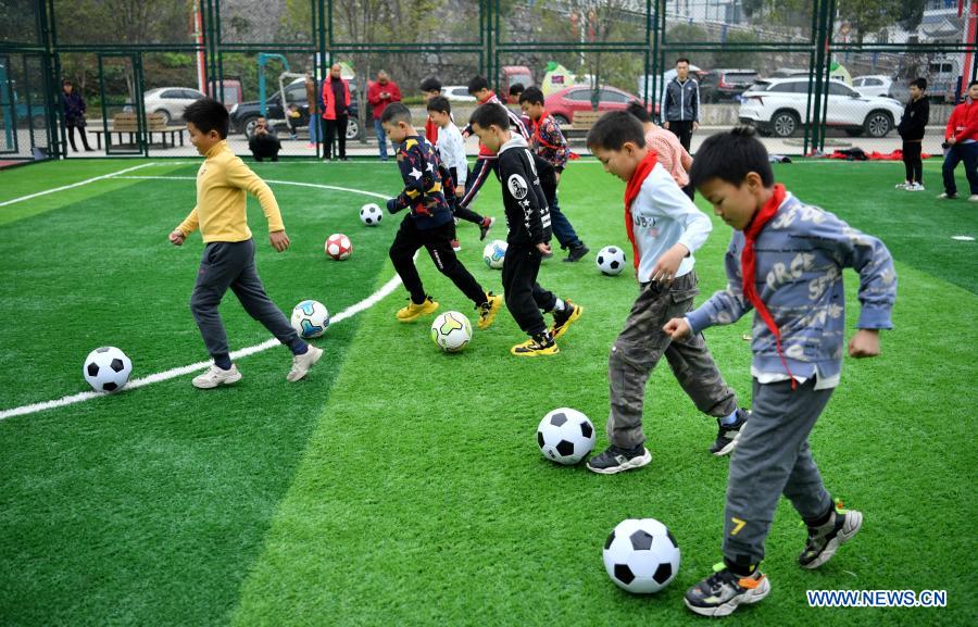 Kids play football during a football class at a resettlement site in Gaoluo Town of Xuan
