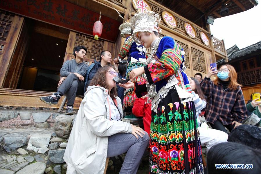 A villager of the Miao ethnic group proposes a toast to a tourist at Langde Village of Miao ethnic group in Leishan County, Qiandongnan Miao and Dong Autonomous Prefecture, southwest China