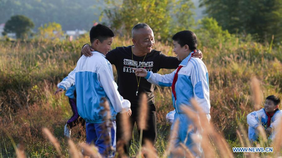 Photo taken on Nov. 10, 2020 shows Zhu Zhihui (C) giving instructions to the students of Matian School before a wrestling competition in Pingxiang, east China