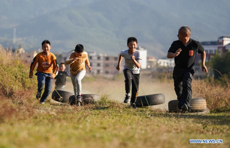 Photo taken on Nov. 12, 2020 shows Zhu Zhihui (1st R) and student of Matian School taking part in a training session in Pingxiang, east China