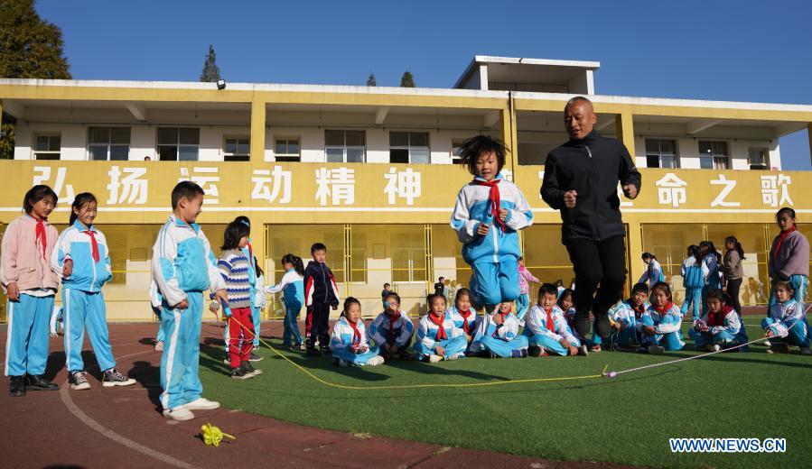 Photo taken on Nov. 10, 2020 shows Zhu Zhihui (1st R, front) and students of Matian School jumping rope in Pingxiang, east China