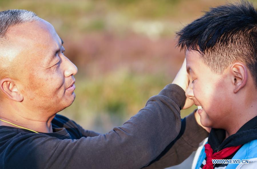 Photo taken on Nov. 10, 2020 shows Zhu Zhihui (L) wiping sweat for a student of Matian School during a training session in Pingxiang, east China