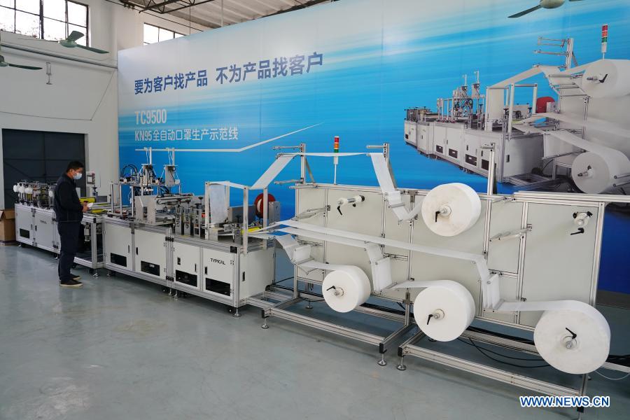 An engineer adjusts an automatic face mask production line in a workshop in the Lintong Production Base of the China Typical Industries Group Co., Ltd., a state-owned enterprise, in Xi