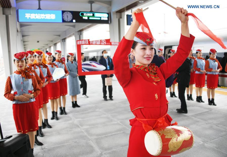 Staff members celebrate during the inauguration of the Weifang-Laixi high-speed railway at the Pingdu Railway Station in Pingdu City, east China